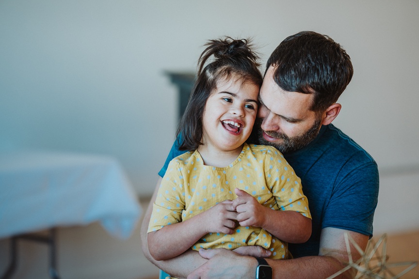 Father holding smiling daughter