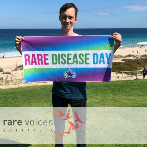 Andrew holding Rare Disease Day banner